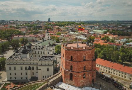 Aerial view of Gediminas castle in capital Vilnius of Lithuania with Lithuanian flag on the tower and skyline of city center in the background.