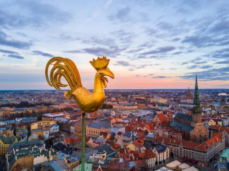 Golden cock on the top of the Dome Cathedral during sunset over Riga. Beautiful wallpaper.