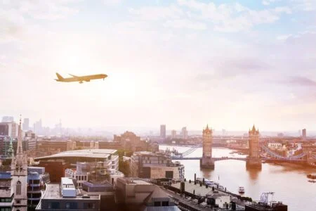 travel to london by plane in the sky over tower bridge