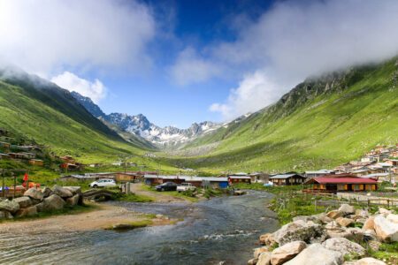 Village houses, clouds and a river running from the valley at Yukari Kavrun Highlands of Ayder Plateau Rize, Turkey. Black Sea Region, Karadeniz in Turkish